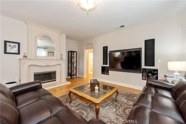 living room with a large fireplace and light wood-type flooring