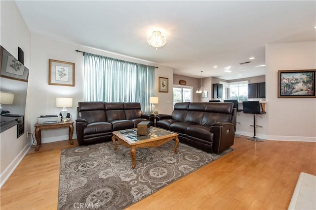 living room featuring light wood-type flooring and a chandelier