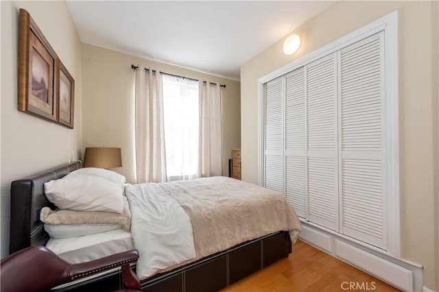 bedroom with light wood-type flooring and a closet