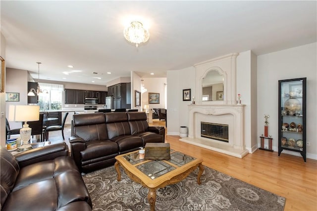 living room featuring light wood-type flooring and an inviting chandelier