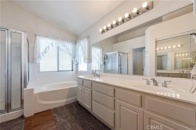 bathroom with hardwood / wood-style floors, vanity, vaulted ceiling, and independent shower and bath