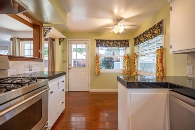 kitchen with ceiling fan, white cabinetry, dark hardwood / wood-style floors, stainless steel range with gas stovetop, and tasteful backsplash