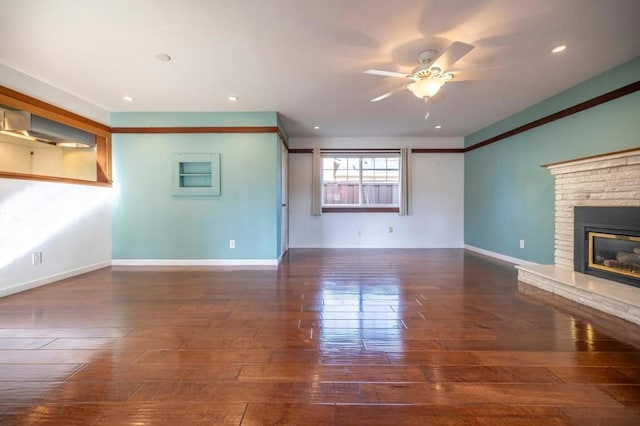 unfurnished living room featuring ceiling fan, dark hardwood / wood-style floors, and a fireplace