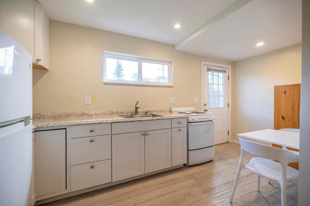 kitchen with white cabinetry, white appliances, sink, and light wood-type flooring