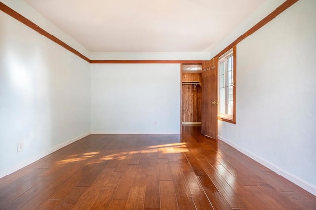 unfurnished room with dark wood-type flooring