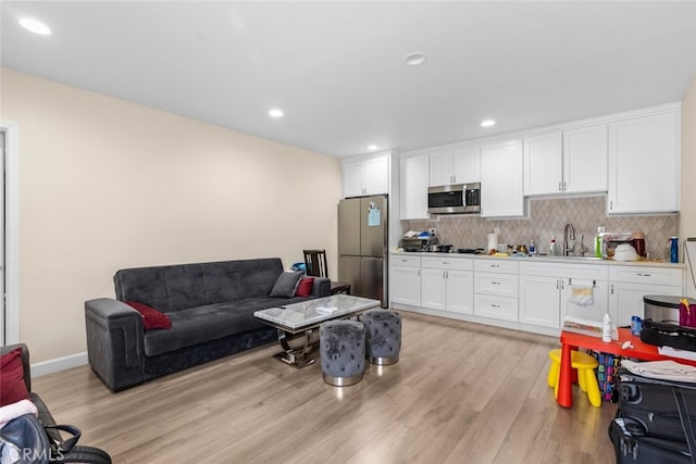 living room with sink and light hardwood / wood-style flooring