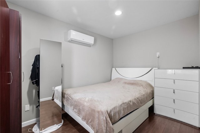 bedroom featuring a wall mounted AC and dark hardwood / wood-style floors