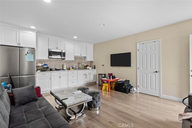 living room featuring sink and light hardwood / wood-style floors