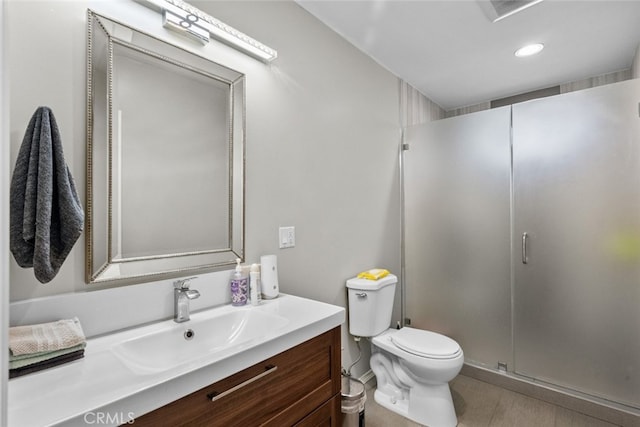 bathroom with toilet, vanity, and walk in shower