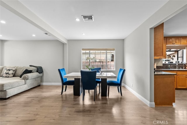 dining space featuring light hardwood / wood-style flooring and sink