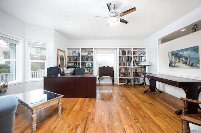 home office with ceiling fan, a healthy amount of sunlight, and light hardwood / wood-style flooring