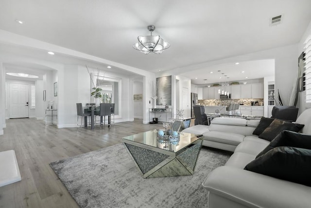 living room with a chandelier and light hardwood / wood-style flooring