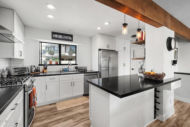 kitchen with white cabinets, light wood-type flooring, a breakfast bar area, and appliances with stainless steel finishes