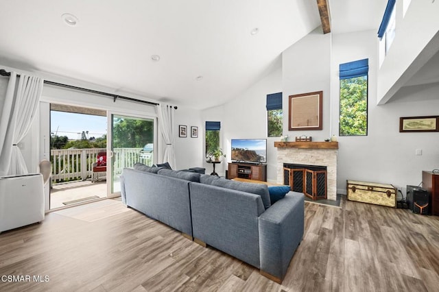 living room with a fireplace, hardwood / wood-style floors, high vaulted ceiling, and beam ceiling