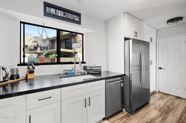 kitchen with backsplash, white cabinetry, sink, and appliances with stainless steel finishes