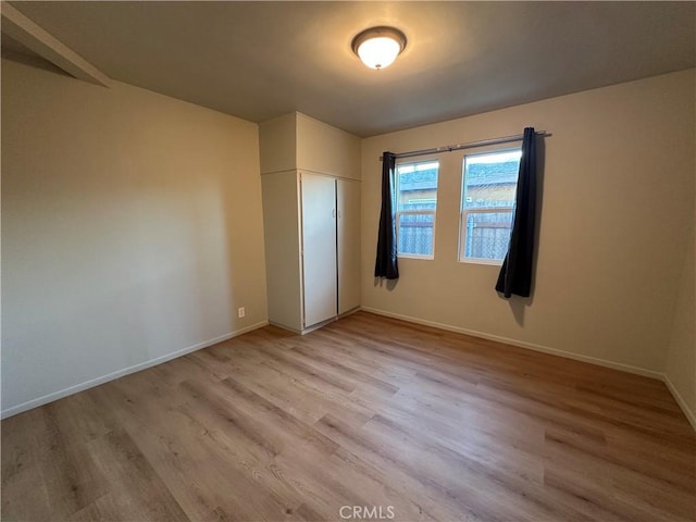 unfurnished bedroom with light hardwood / wood-style floors and a closet