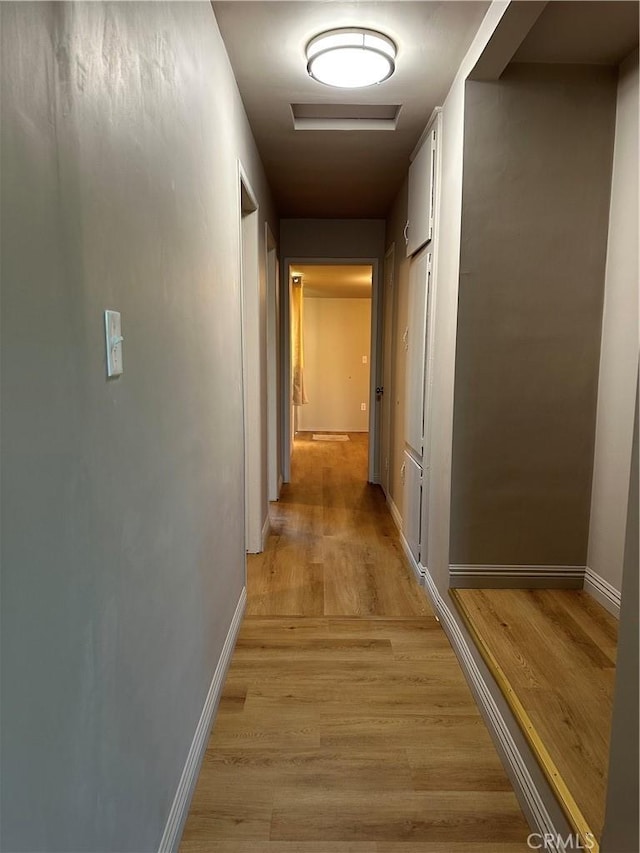 corridor with light hardwood / wood-style flooring