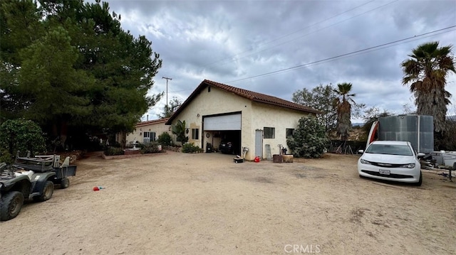 view of property exterior with a garage and an outbuilding