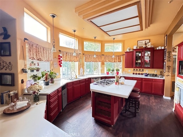 kitchen with pendant lighting, dark hardwood / wood-style floors, a kitchen island, and sink