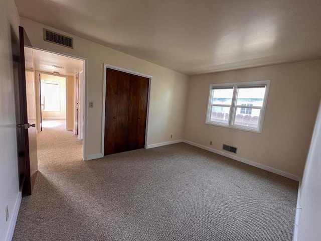 unfurnished bedroom featuring carpet and a closet