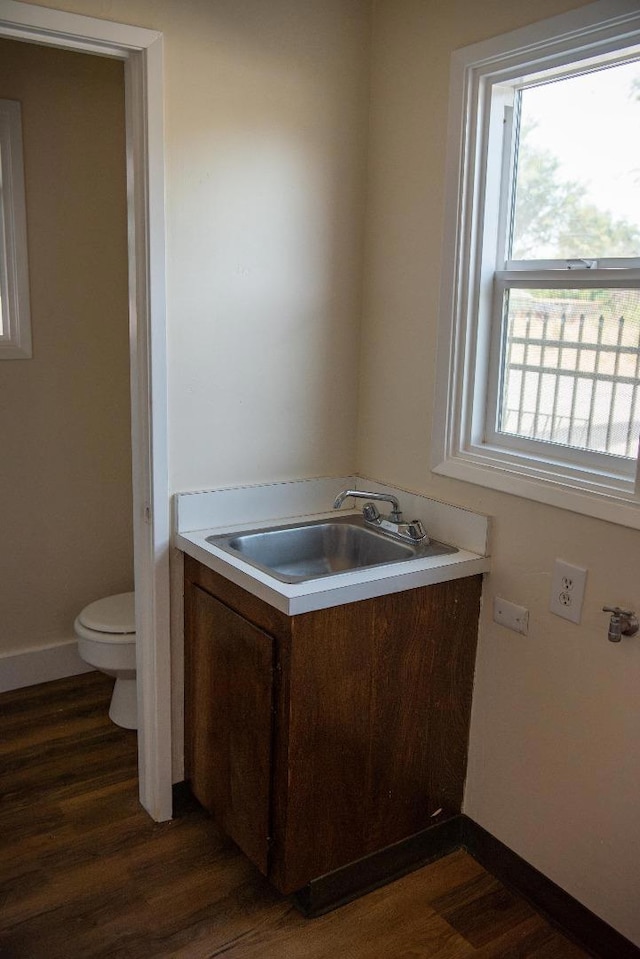 bathroom with hardwood / wood-style floors, vanity, and toilet