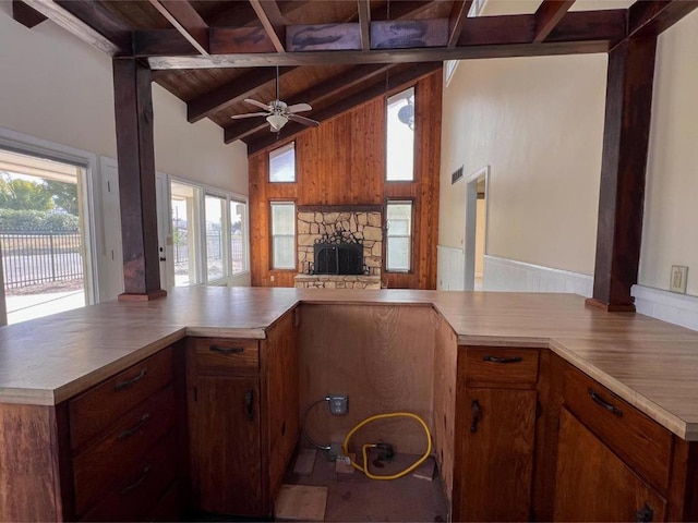 kitchen with kitchen peninsula, ceiling fan, a fireplace, and wood ceiling