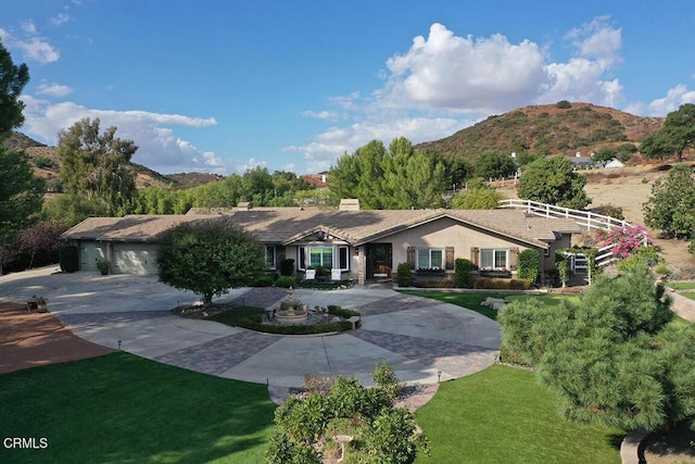 ranch-style home with a mountain view and a front yard