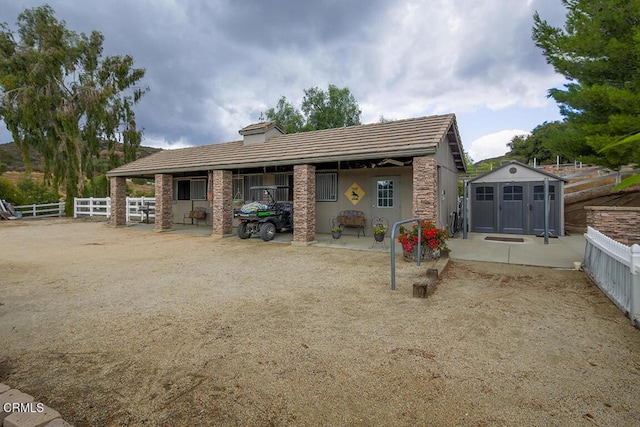 rear view of house with a storage unit