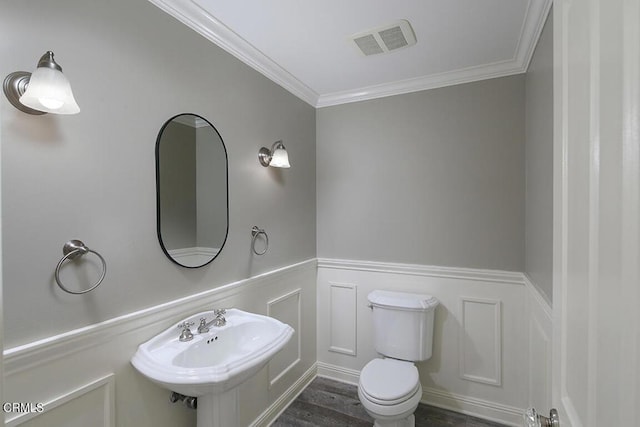 bathroom featuring hardwood / wood-style floors, toilet, ornamental molding, and sink