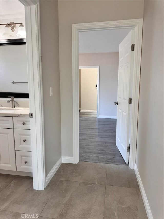 hallway with sink and light hardwood / wood-style flooring