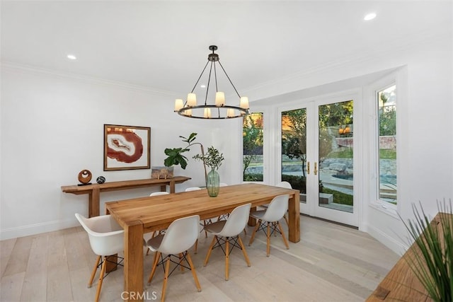 dining space featuring light wood finished floors, baseboards, ornamental molding, a notable chandelier, and recessed lighting