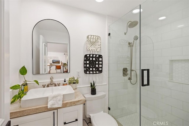 full bathroom featuring vanity, a shower stall, and toilet