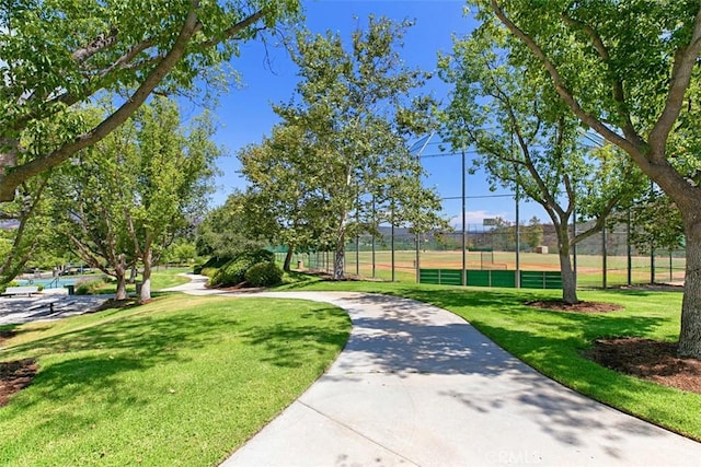 view of home's community with fence and a lawn