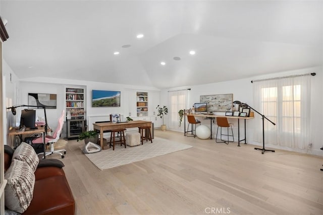 home office featuring lofted ceiling, built in shelves, wood finished floors, and recessed lighting