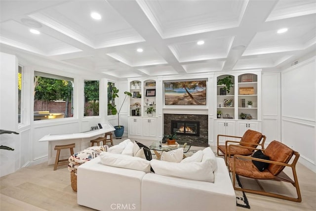 living room featuring beamed ceiling, built in features, a high end fireplace, and a decorative wall