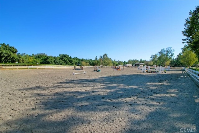 view of yard featuring a rural view, an enclosed area, and fence