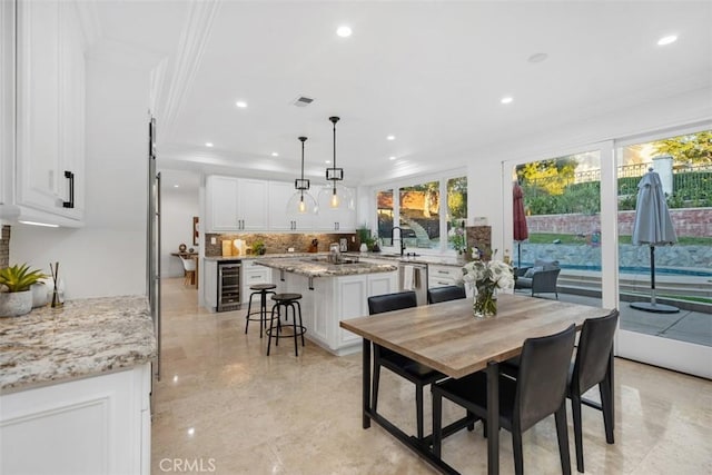 dining area with recessed lighting, beverage cooler, visible vents, and crown molding