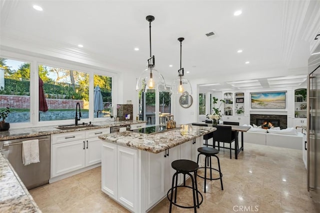 kitchen with a center island, a lit fireplace, black electric stovetop, stainless steel dishwasher, and a sink