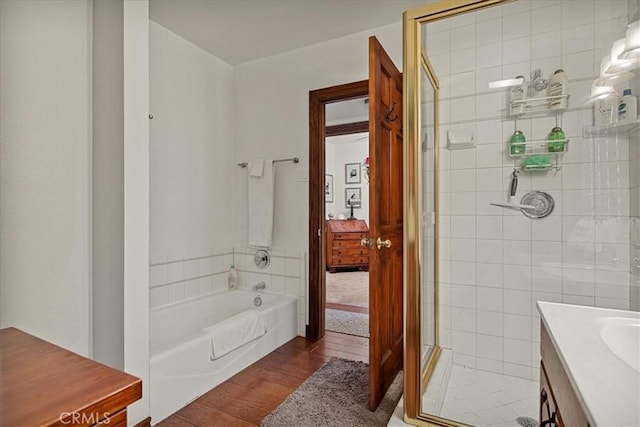 bathroom featuring hardwood / wood-style flooring, vanity, and shower with separate bathtub