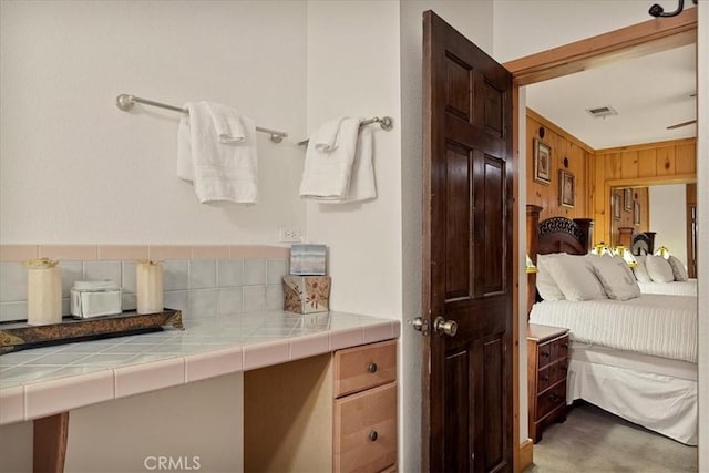 bathroom featuring backsplash and wooden walls