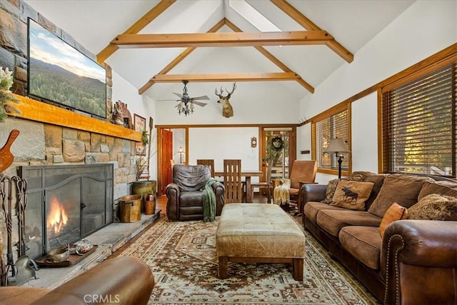 living room featuring a fireplace, beam ceiling, high vaulted ceiling, and ceiling fan