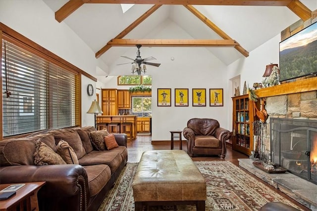 living room featuring ceiling fan, high vaulted ceiling, beamed ceiling, a fireplace, and hardwood / wood-style floors