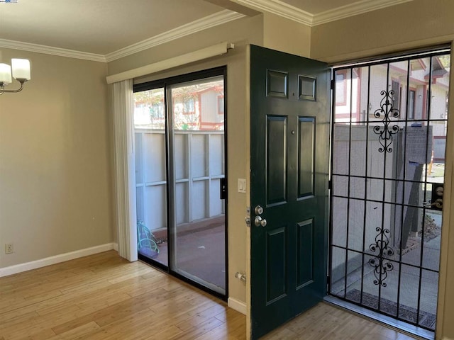 doorway to outside featuring wood-type flooring, plenty of natural light, crown molding, and a notable chandelier