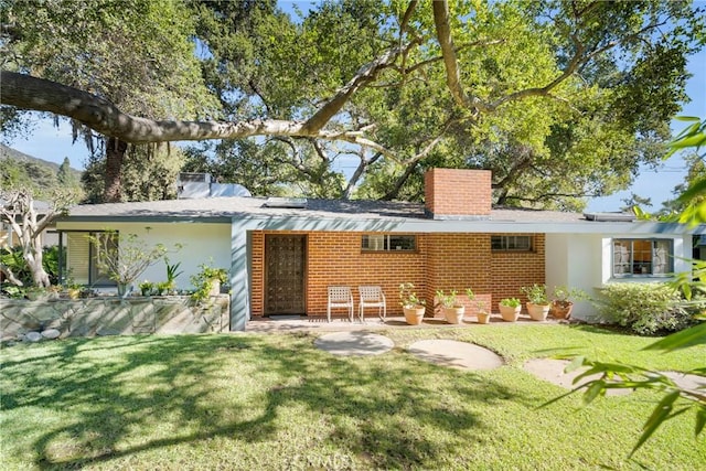 rear view of property featuring a lawn