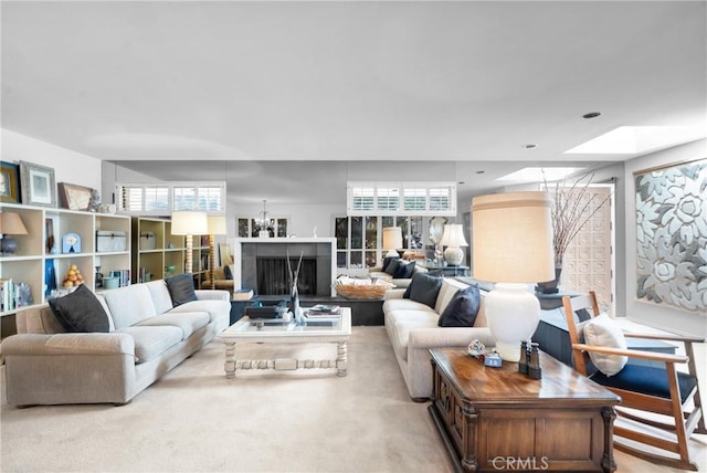 carpeted living room with a skylight and a healthy amount of sunlight