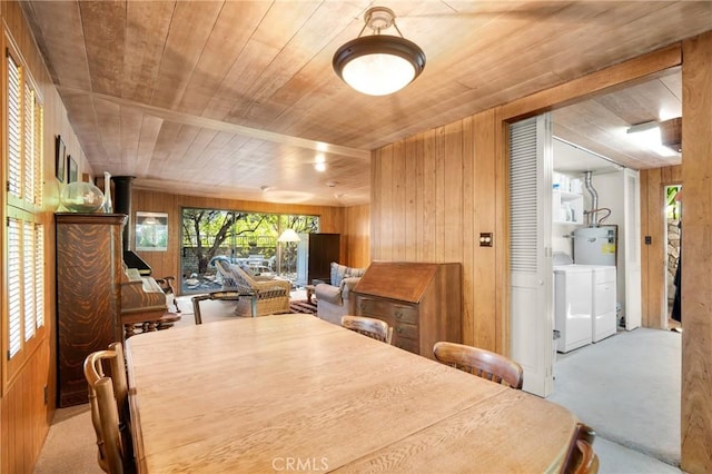 dining room featuring wood walls, light colored carpet, wooden ceiling, and separate washer and dryer