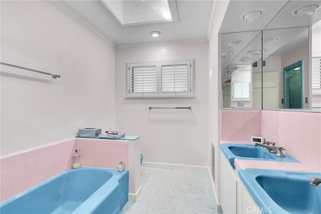 bathroom featuring vanity, crown molding, and a tub