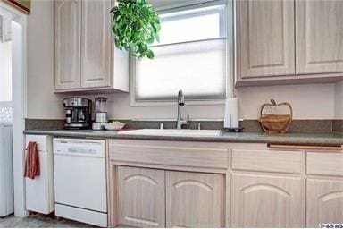 kitchen with dishwasher, sink, and light brown cabinetry