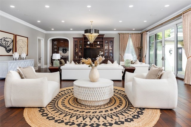 living room with dark hardwood / wood-style flooring, ornamental molding, and a notable chandelier