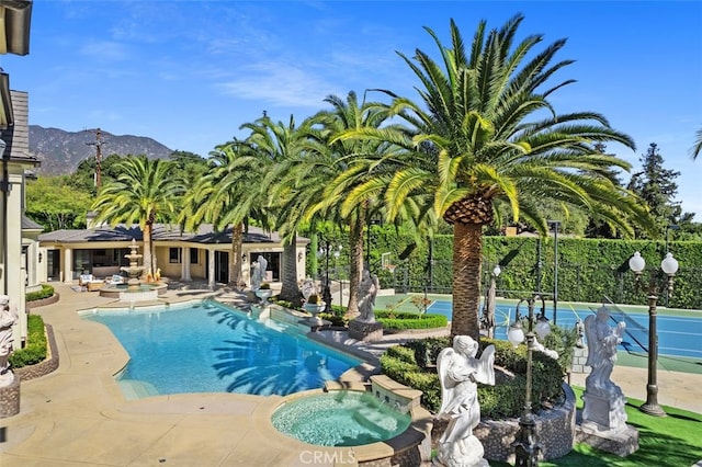 view of swimming pool featuring a mountain view, a patio, an in ground hot tub, and tennis court